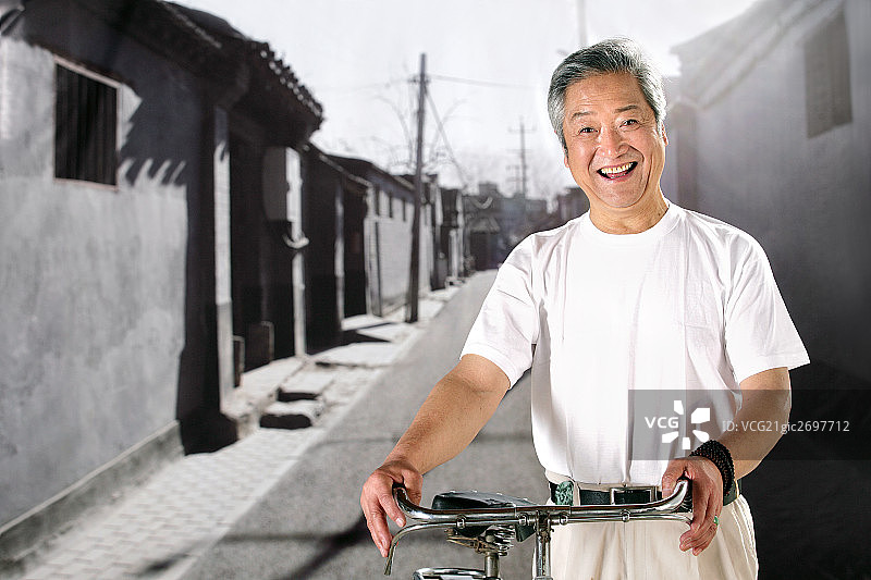 oriental senior adult holding the bicycle图片素材