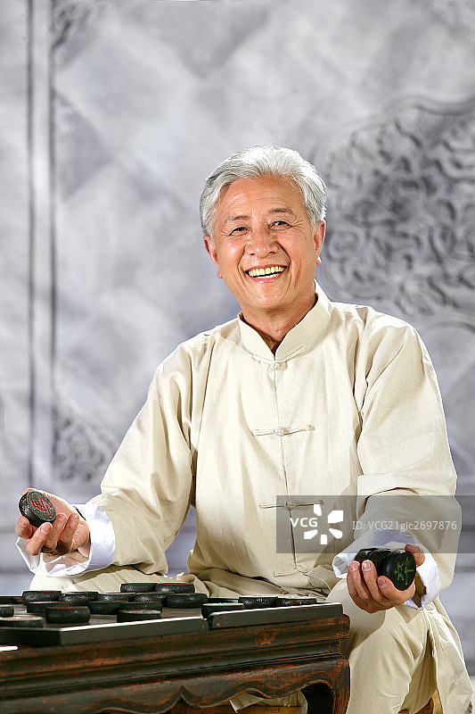 oriental senior adult playing chinese chess图片素材