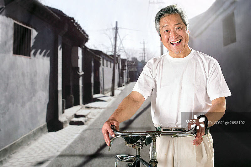 oriental senior adult holding the bicycle图片素材