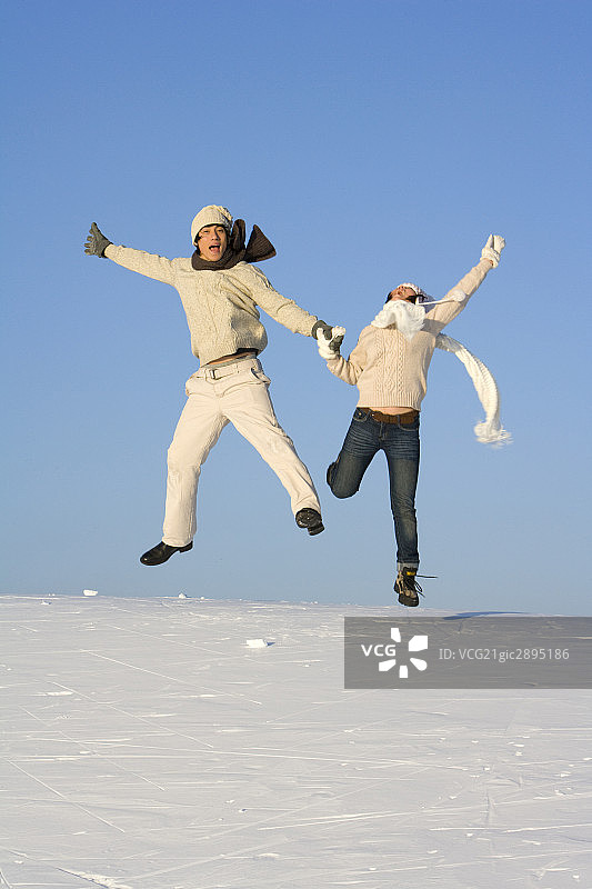 雪地上玩耍的年轻情侣图片素材