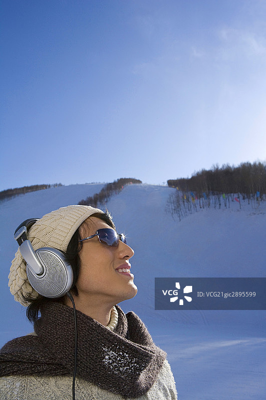 雪地上听音乐的年轻男子图片素材