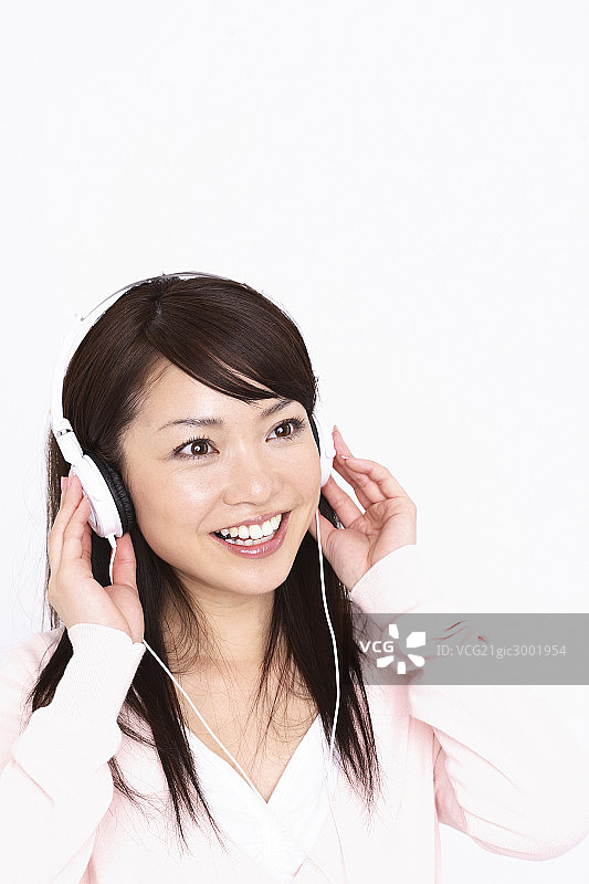 Asian woman listening to the music图片素材