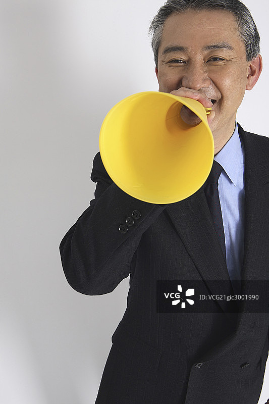 Asian executive cheering with a megaphone图片素材