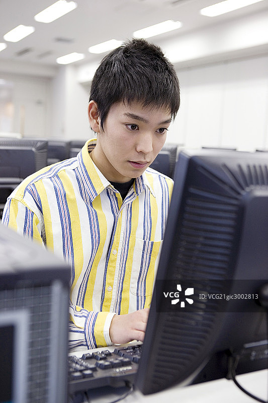 Asian student operating a PC图片素材