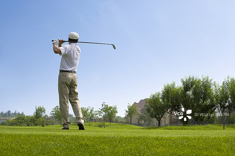 挥杆的高尔夫男球手图片素材