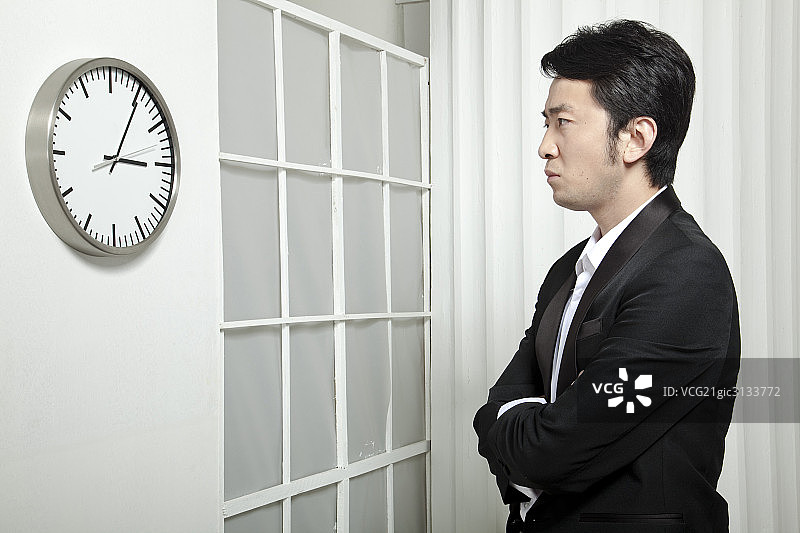 一个商务男士注视着挂钟图片素材