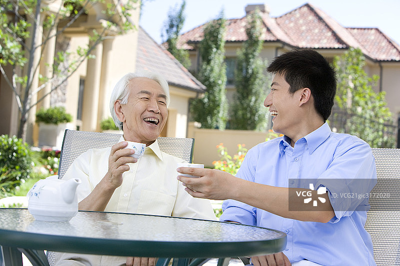 东方父子俩喝茶聊天图片素材