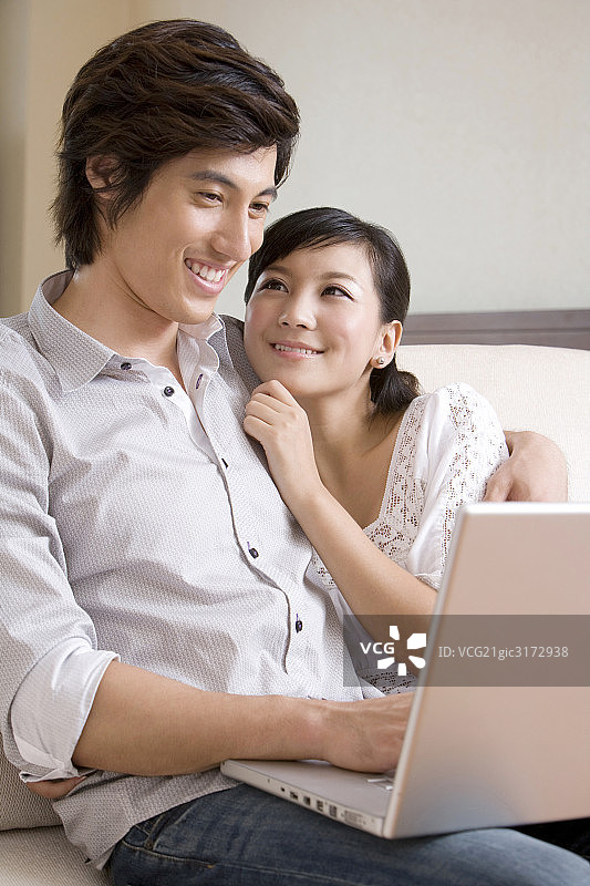 用笔记本电脑的年轻夫妇图片素材