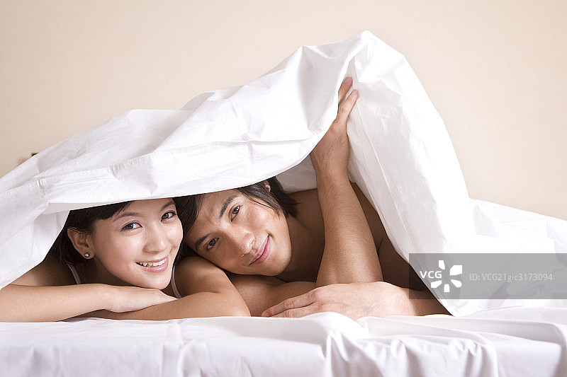 趴在床上的年轻夫妇图片素材