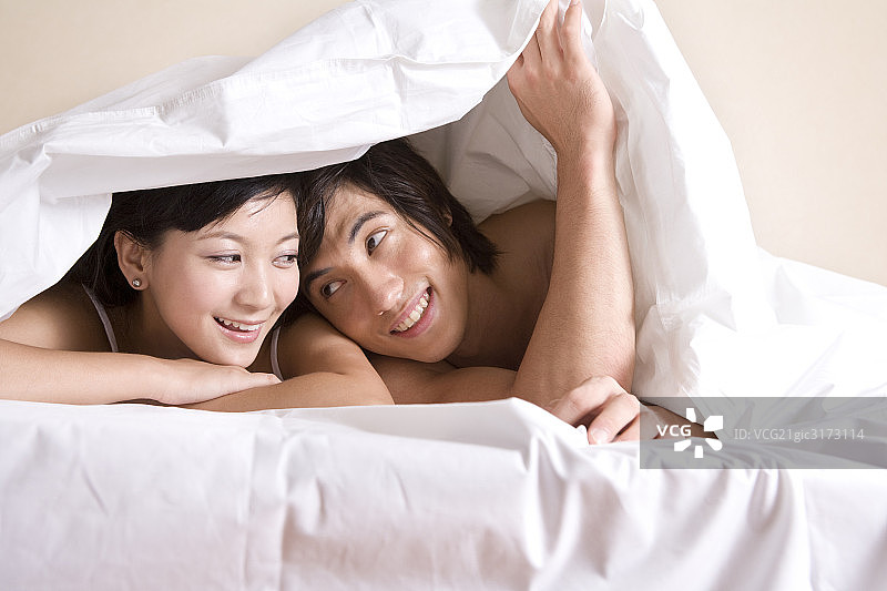 趴在床上的年轻夫妇图片素材