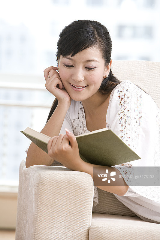 在沙发上看书的女孩图片素材