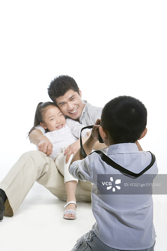 小男孩给父女拍照图片素材