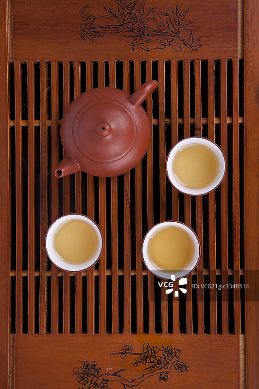 放在木盘上装有茶水的紫砂壶图片素材