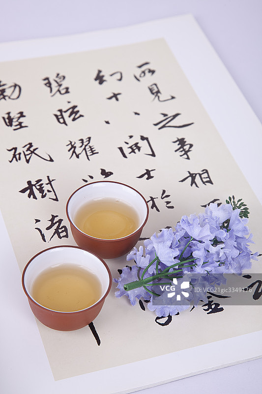 装有茶水的紫砂茶具与中国书法图片素材