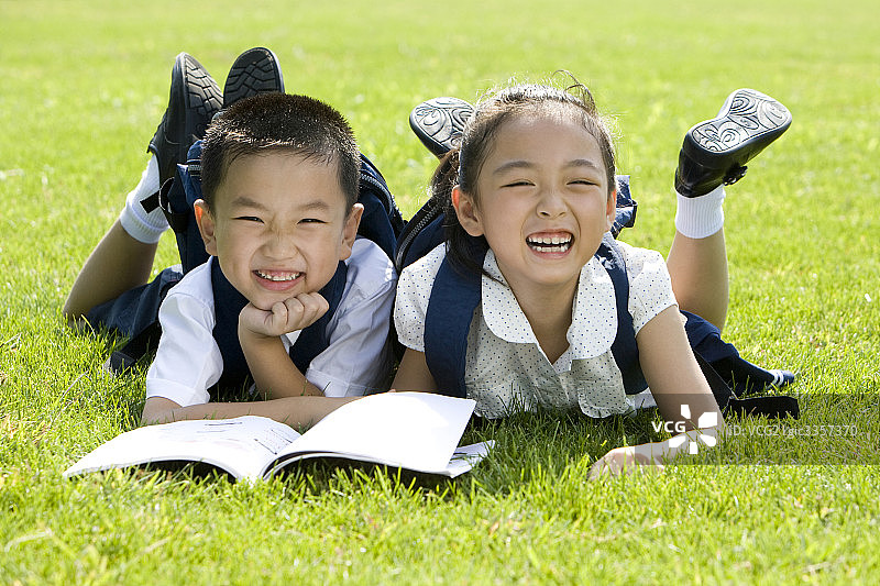 两个在草地上看书的小学生图片素材