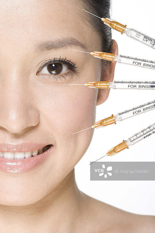 美丽年轻女子和注射器图片素材