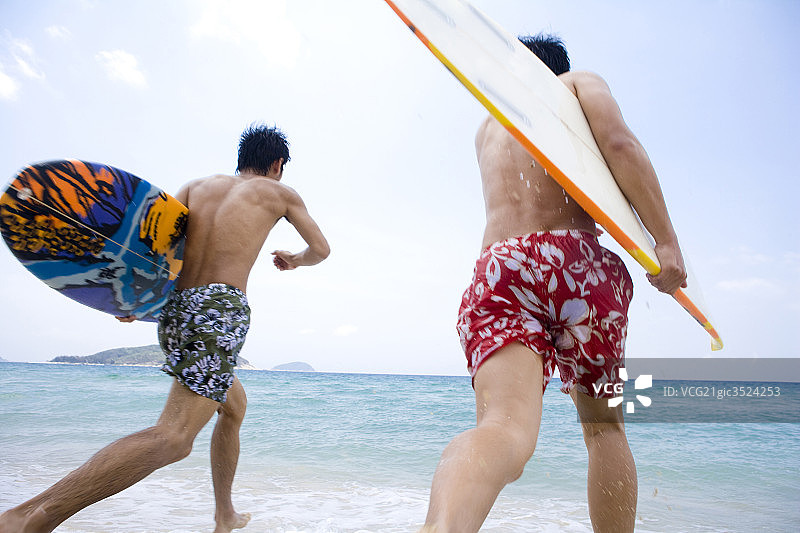 拿着冲浪板奔跑的男孩图片素材