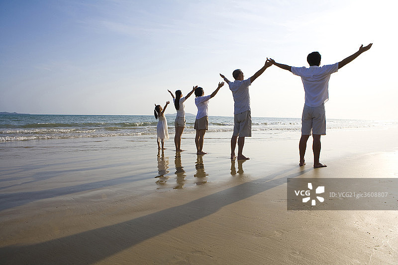 全家人在沙滩上张开双臂图片素材