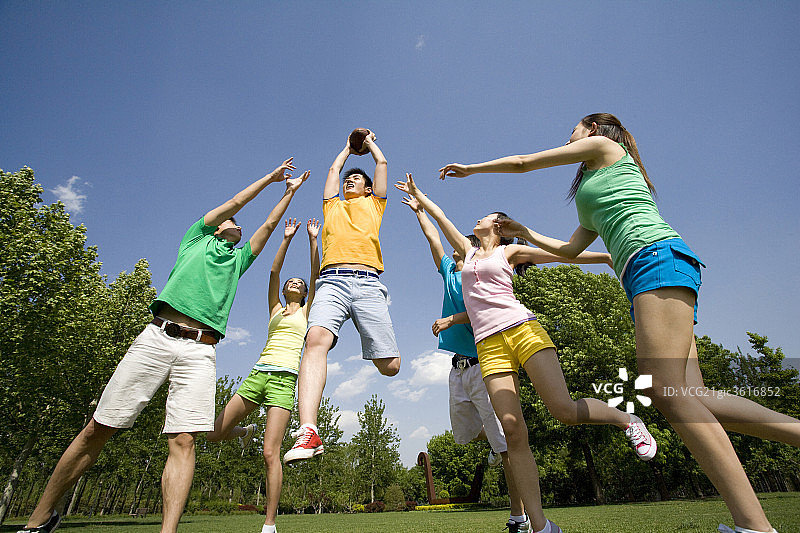 年青人争抢橄榄球图片素材
