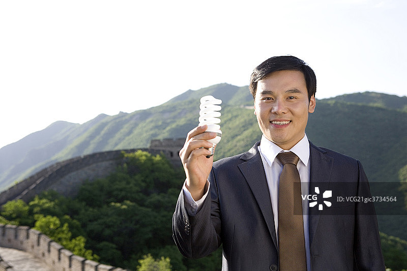 商务男士手握节能灯泡图片素材