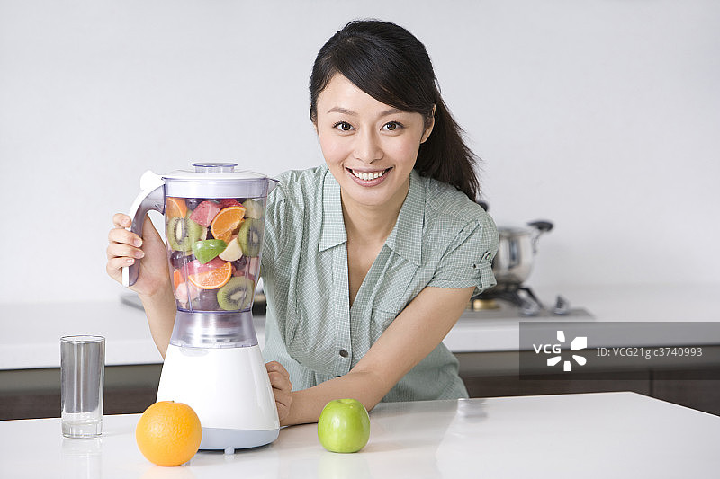 青年女子在厨房做果汁图片素材