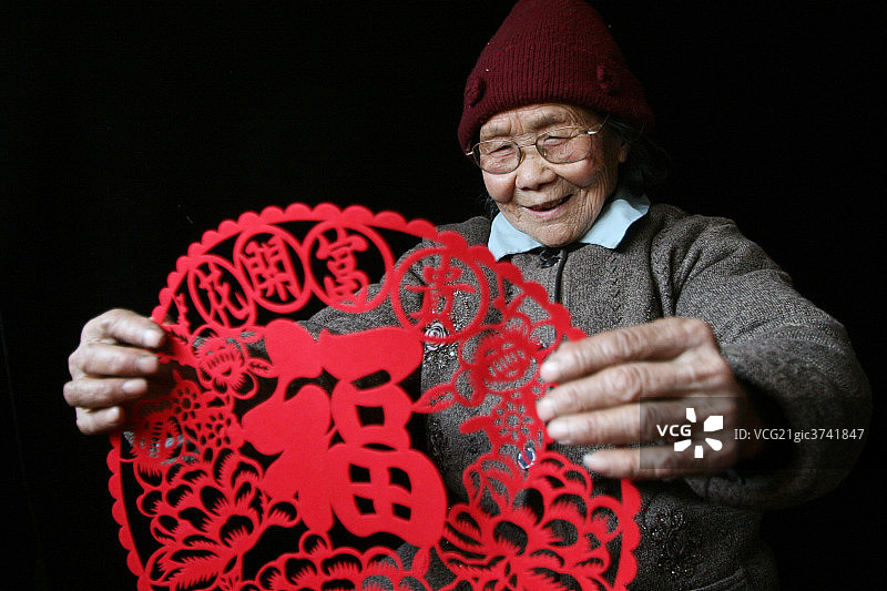 东方老人手拿剪纸图片素材