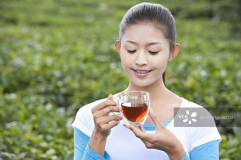 青年女子在茶园喝茶图片素材