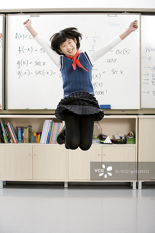 小学生在黑板前跳跃图片素材