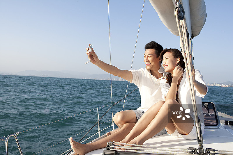 青年夫妇在帆船上拍照图片素材