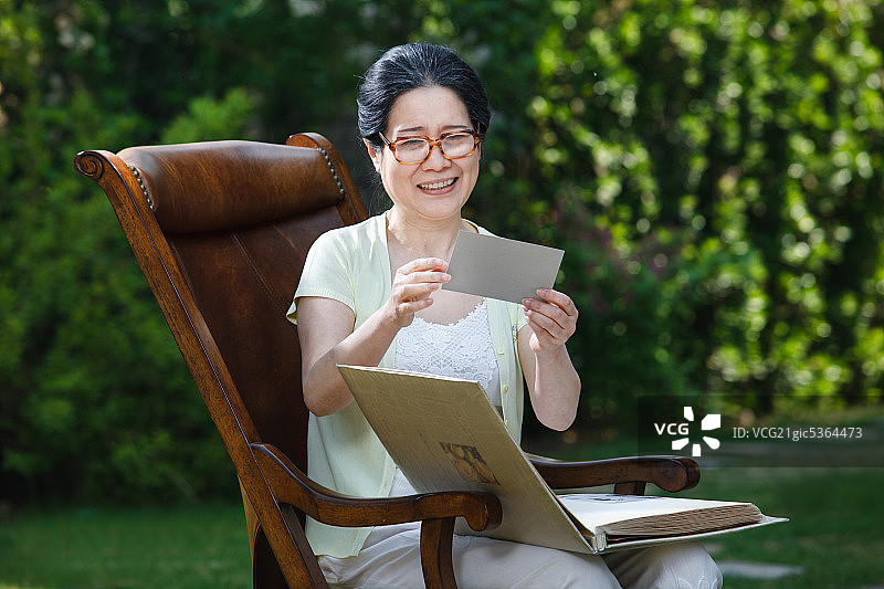 东方老年女人看照片图片素材
