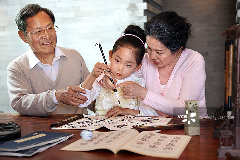 东方老人和孩子一起练书法图片素材