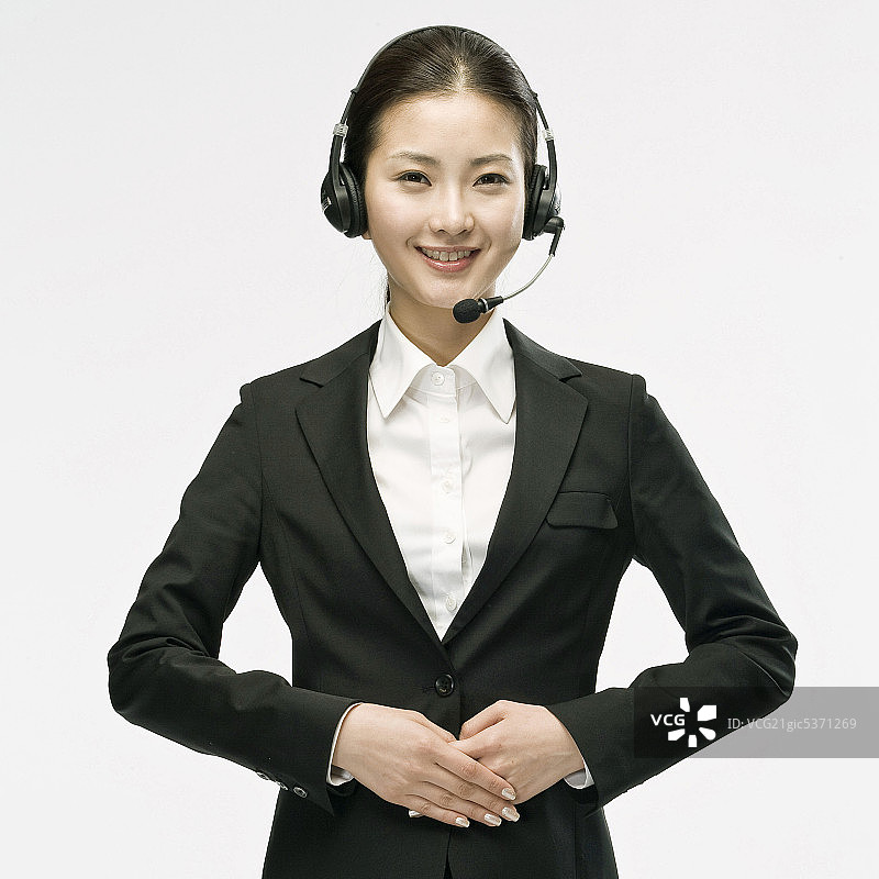使用耳机的微笑女商人图片素材