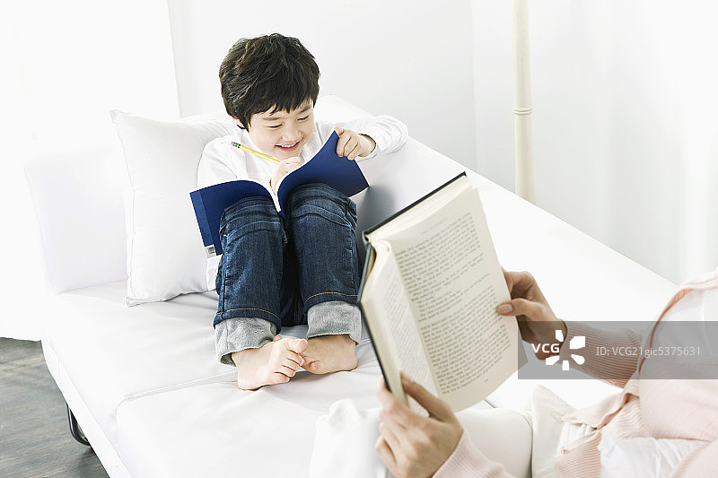 母子坐在沙发上读书图片素材
