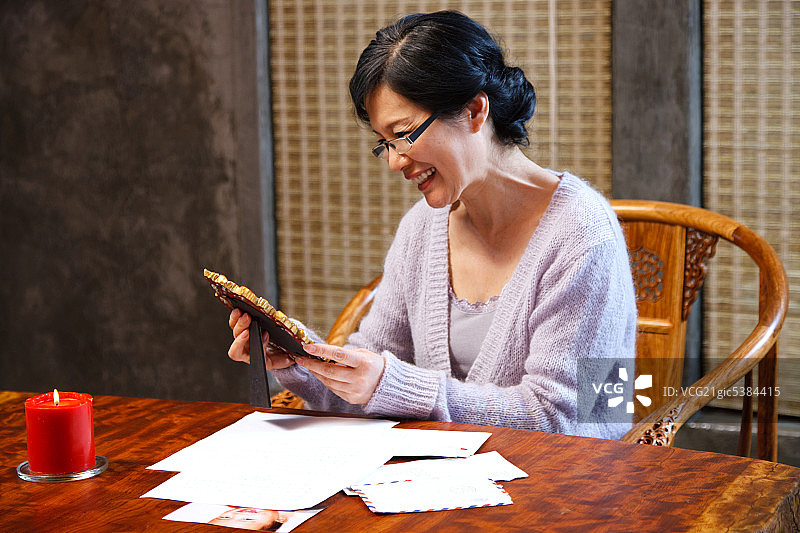 东方老年女人看照片图片素材