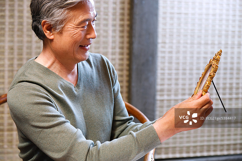 东方老年男人看照片图片素材