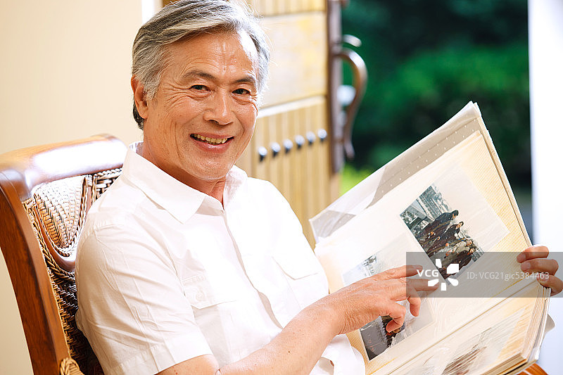东方老年男人看相册图片素材