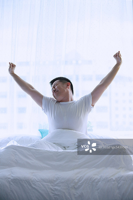 在床上伸懒腰的男人图片素材