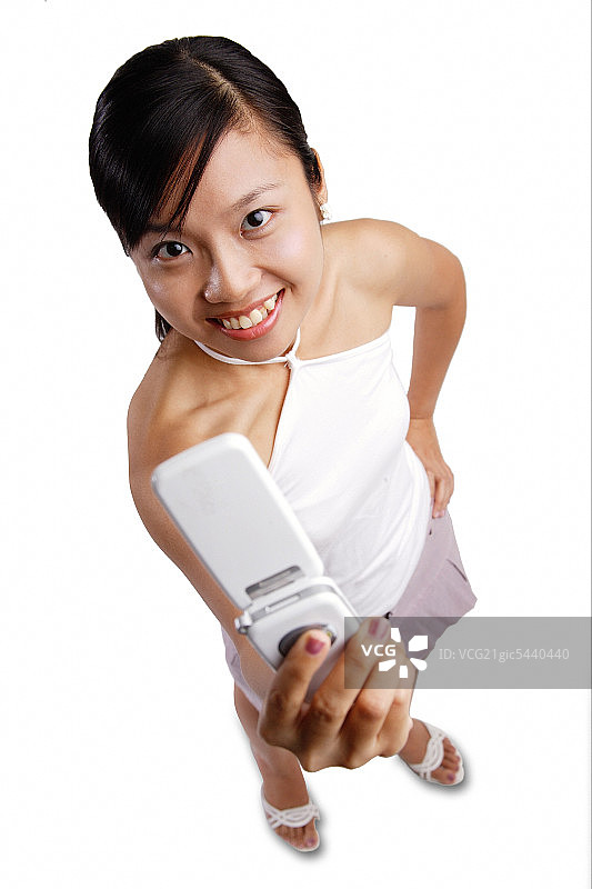 年轻女人手拿手机看着镜头图片素材