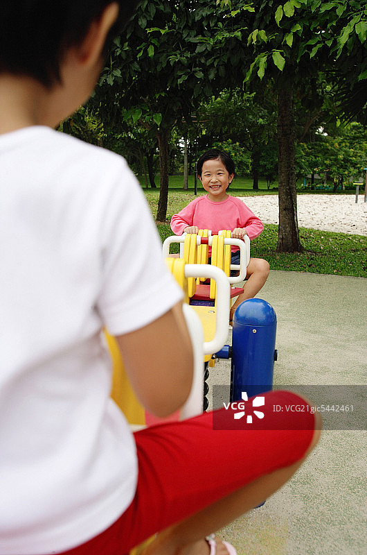 在跷跷板上玩耍的两个女孩图片素材