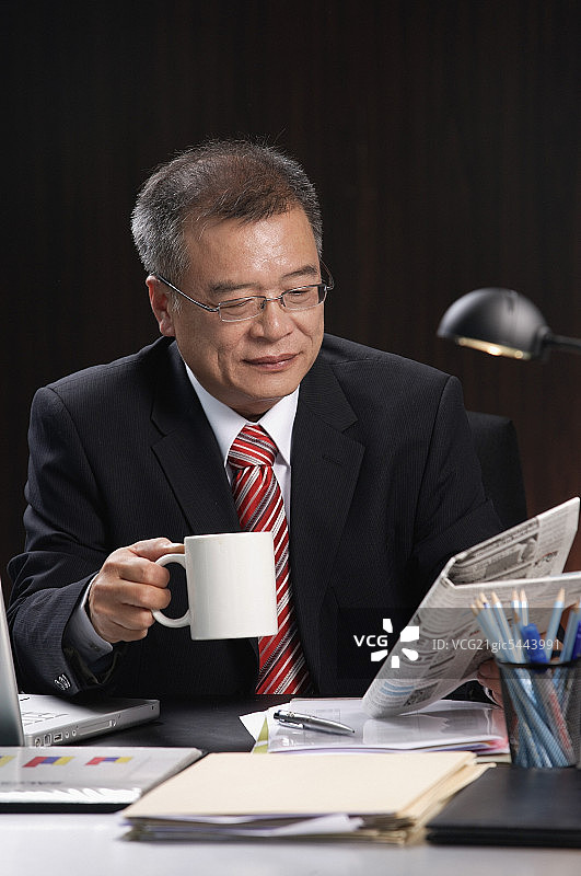 男人在办公桌前工作时饮用饮品图片素材