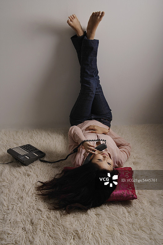 躺在地板上打电话的中国女人图片素材