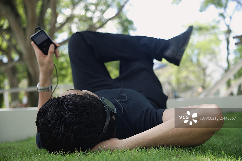 男人在公园里用MP3播放器听音乐图片素材
