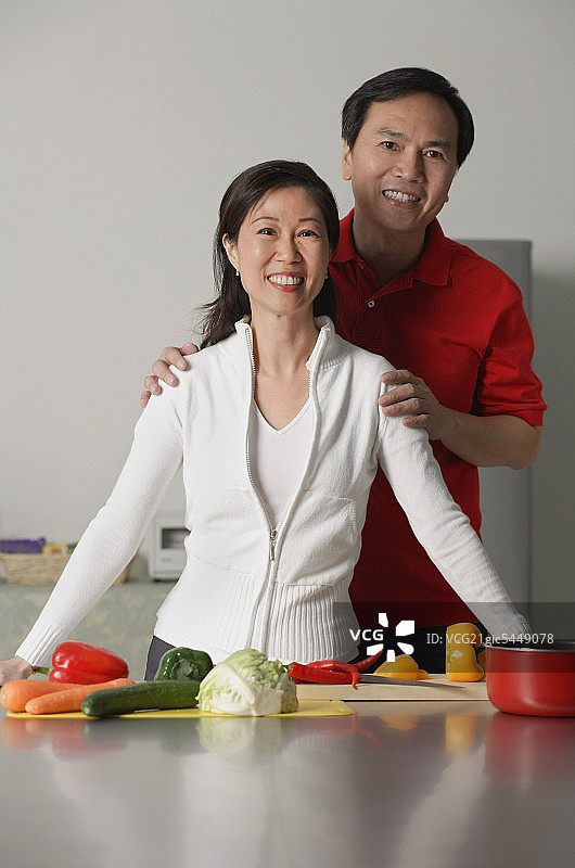 在厨房里对着镜头微笑的中年夫妇图片素材