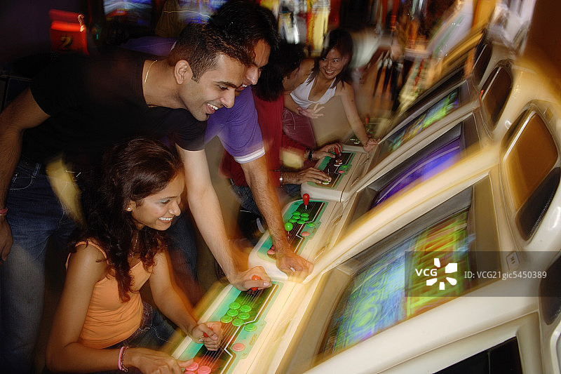 在电子游戏厅玩游戏的年轻人图片素材