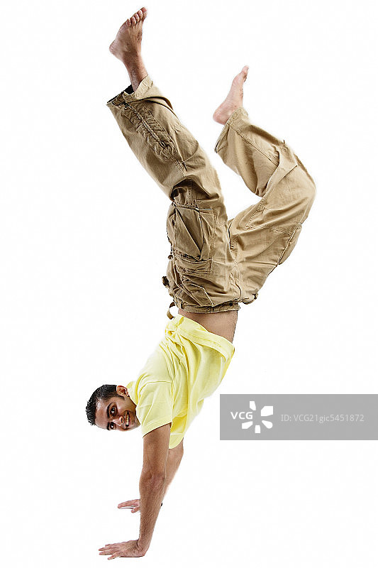 年轻男人倒立，看着镜头图片素材