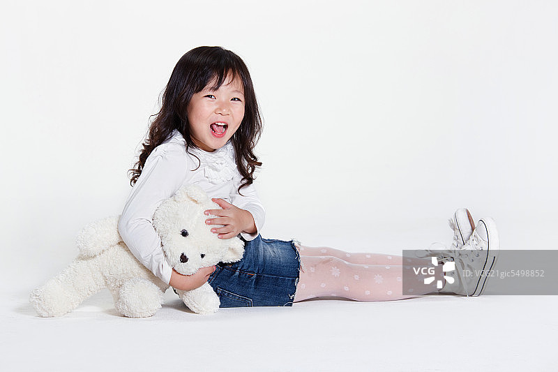 东方儿童抱玩具熊图片素材