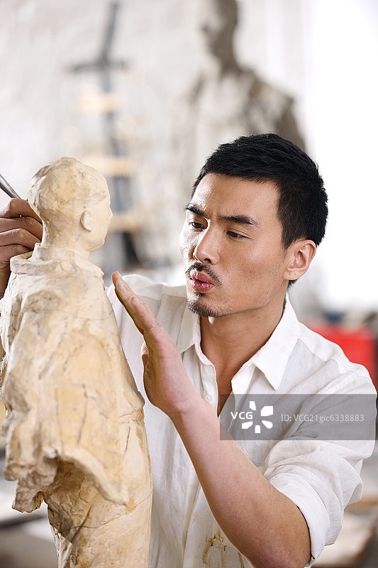 一个男雕塑家在工作室里创作图片素材