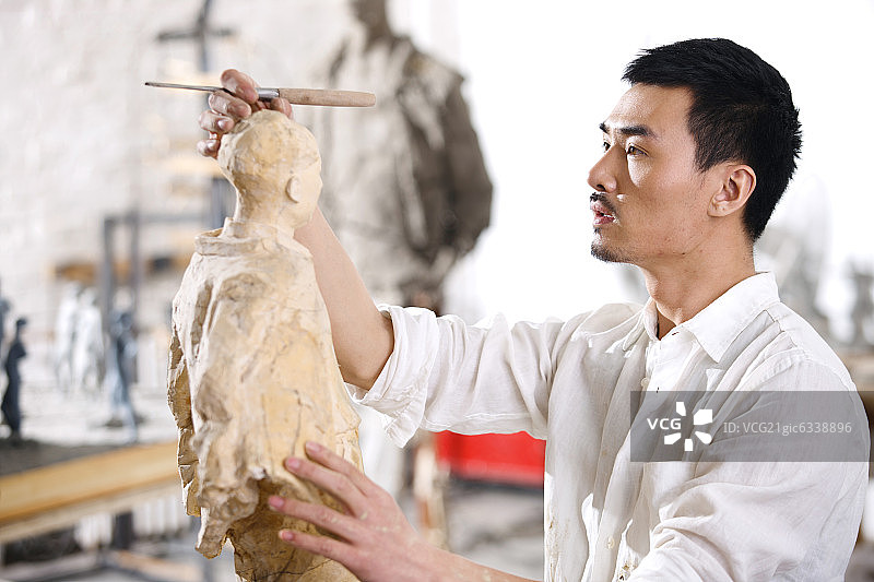 一个男雕塑家在工作室里创作图片素材