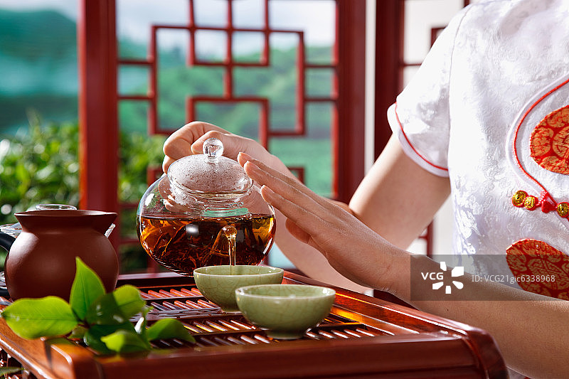 一个东方女孩在茶园的茶舍喝茶图片素材