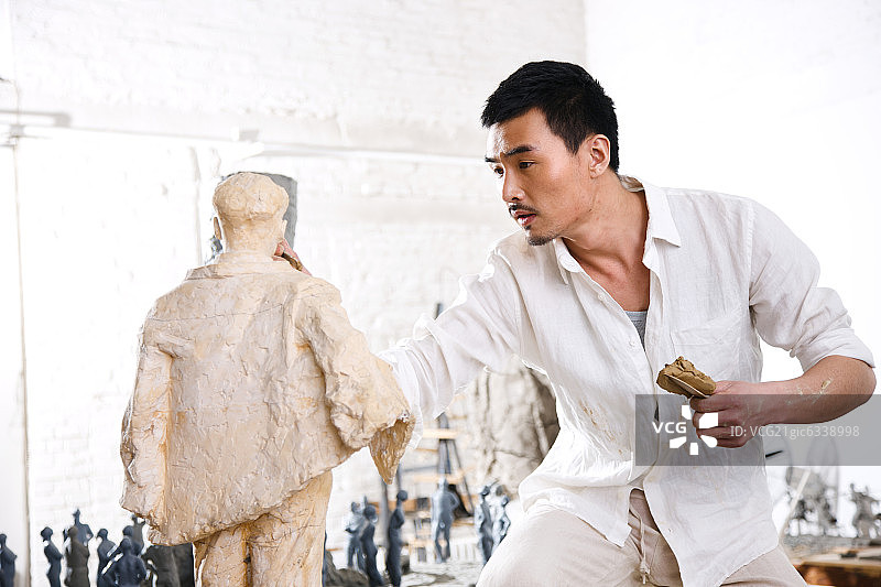 一个男雕塑家在工作室里创作图片素材